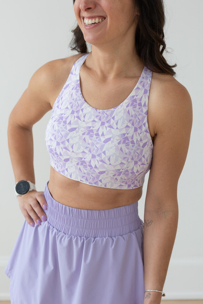 a woman wearing the EMIE Forget About It Sports Bra in lilac geo