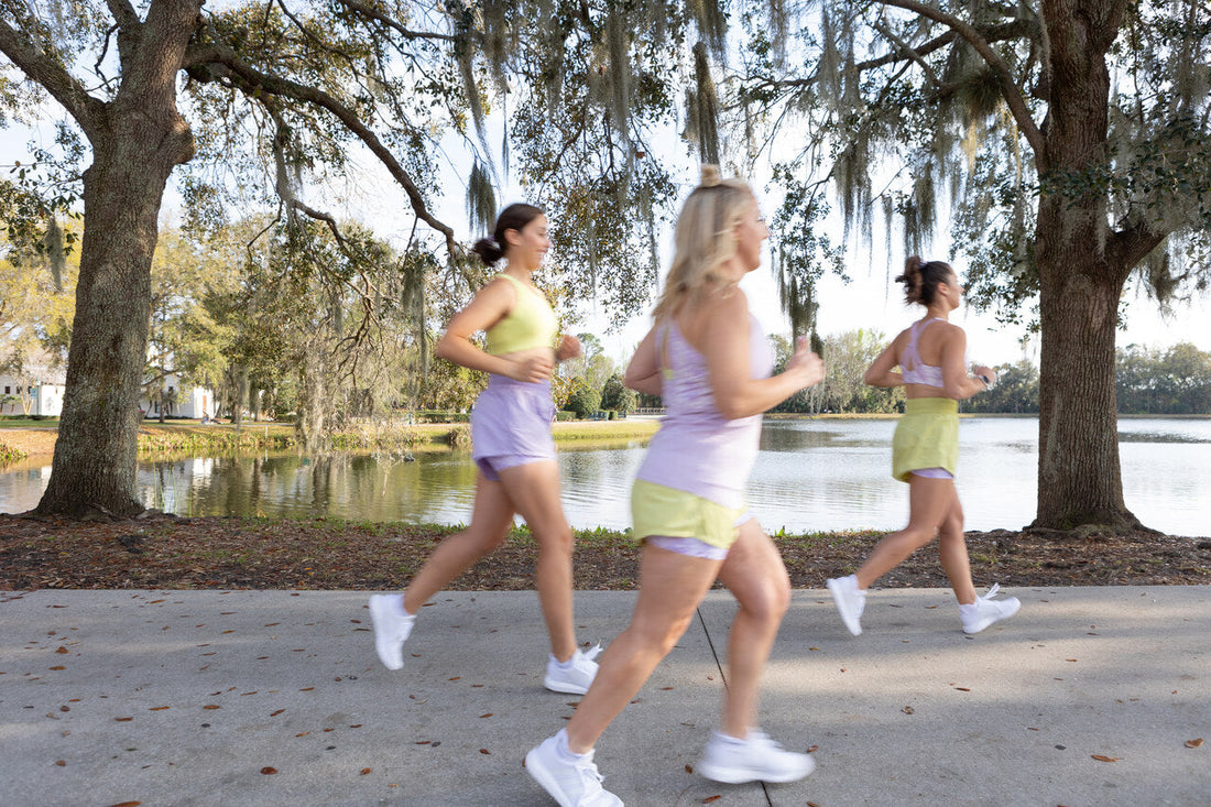 Three women running together on a shaded path during a summer heat wave