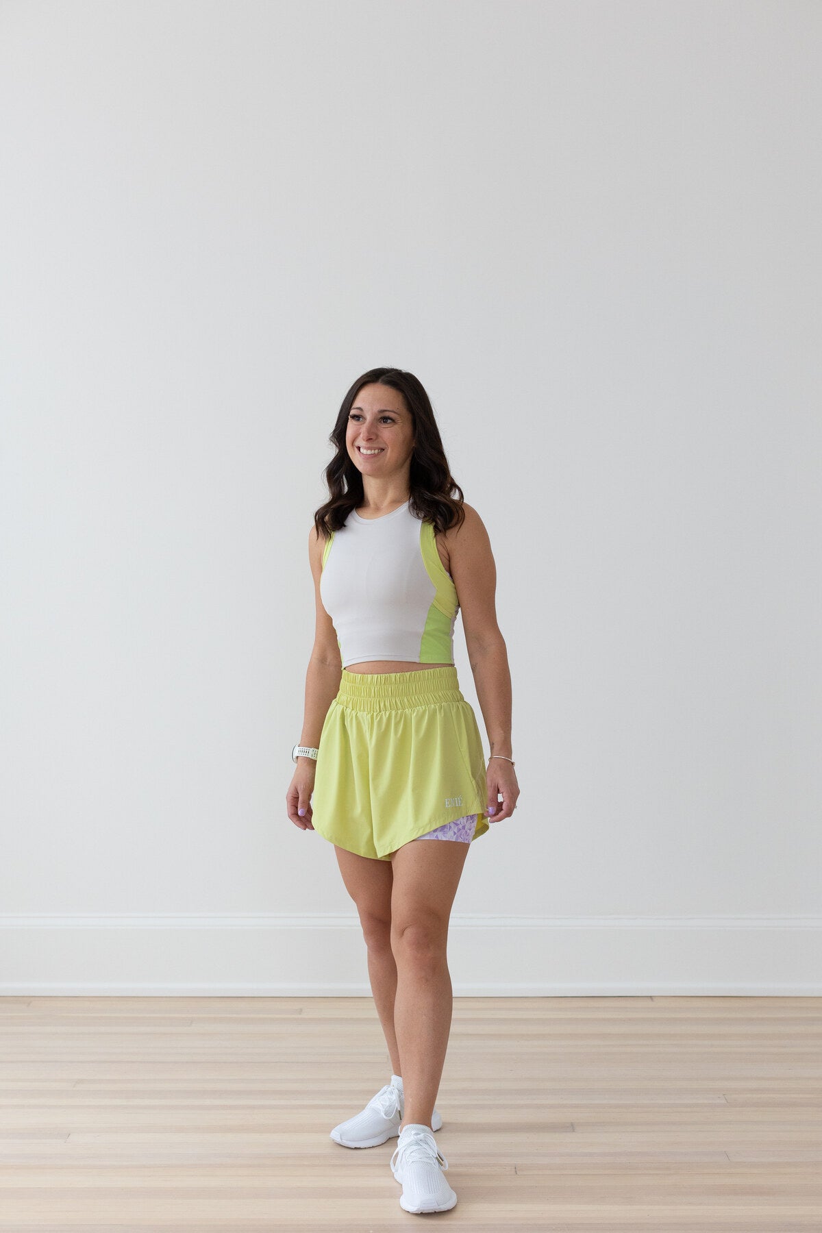 Woman in EMIÉ key lime crop tank and Problem Solved running shorts - matching women's running outfit